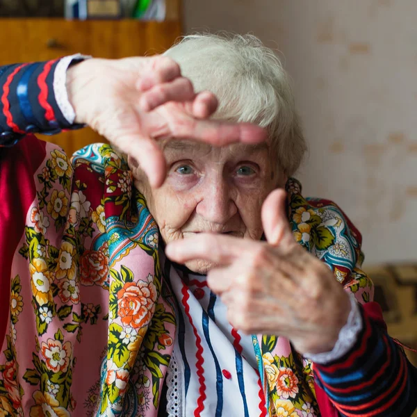 Een Oudere Vrouw Heldere Kleren Shows Door Handen Gebaar Fotolijstjes — Stockfoto