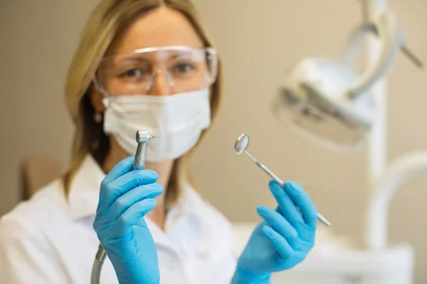 女性歯科医の医師がツーリングを保持し クローズアップを示す — ストック写真