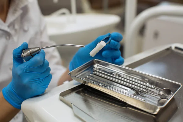 Dentist\'s hands holding detail of dental tools in dental clinic.