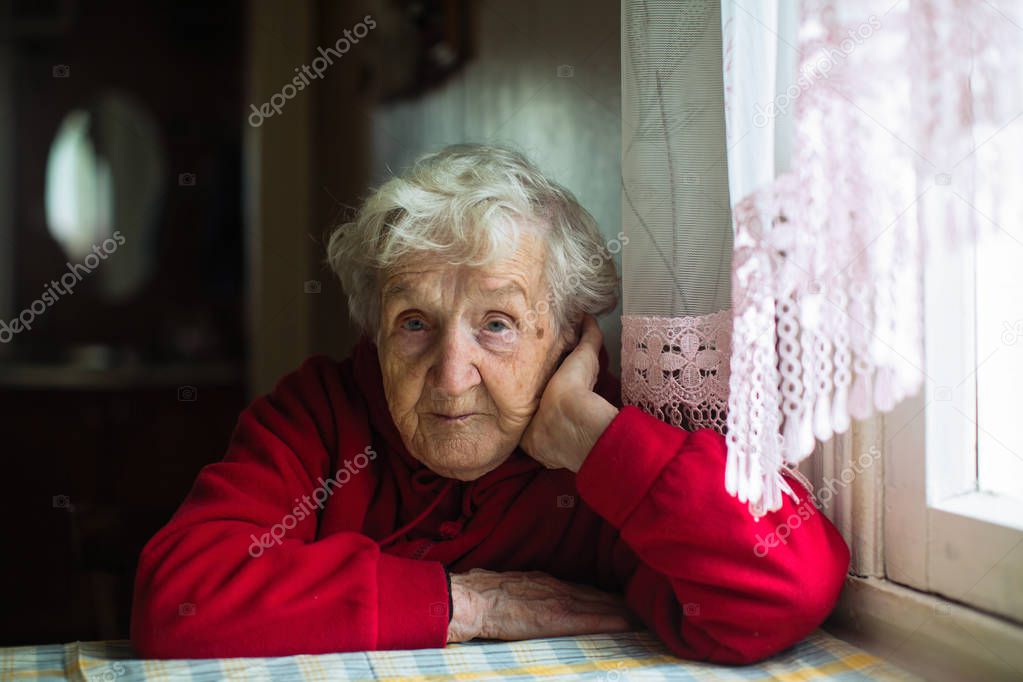 Portrait of an old gray-haired woman. Concept of assistance to lonely pensioners.