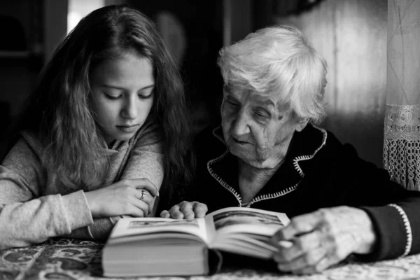 奶奶和一个小孙女在看书 — 图库照片