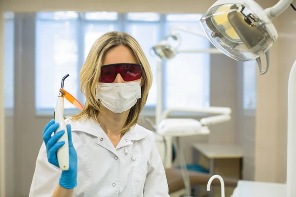 Lekarz Dentysta Okularach Ochronnych Pokazuje Lekkie Leczenie Stomatologiczne Gabinecie Stomatologicznym — Zdjęcie stockowe