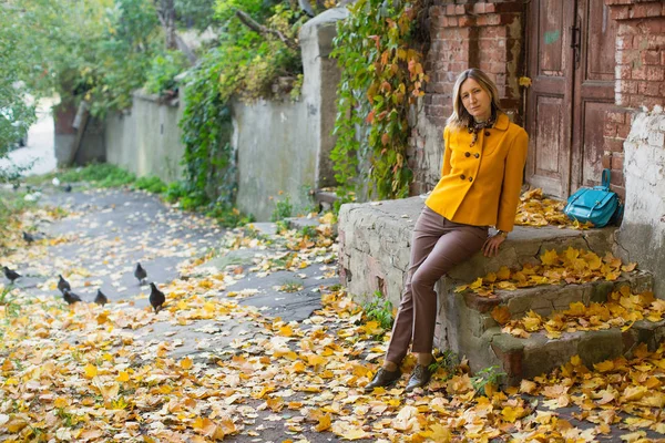 Mulher Elegante Uma Jaqueta Amarela Senta Perto Uma Casa Velha — Fotografia de Stock