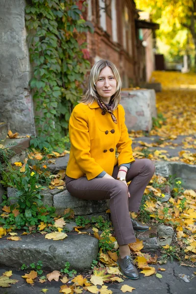 Blondýnka Žluté Bundě Pózuje Podzimní Ulici Červeným Žlutým Listím — Stock fotografie