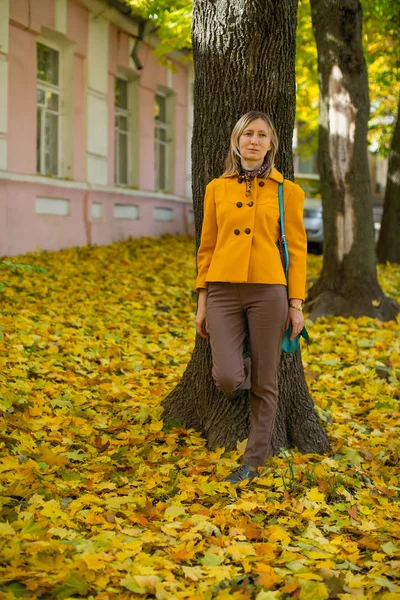 Blond Žena Žluté Bundě Pózuje Podzimní Ulici Červeným Žlutým Listím — Stock fotografie