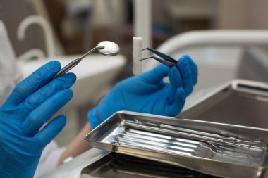 Diş kliniğinde diş aletlerinin detaylarını tutan eller. Tıp ve Bilim.