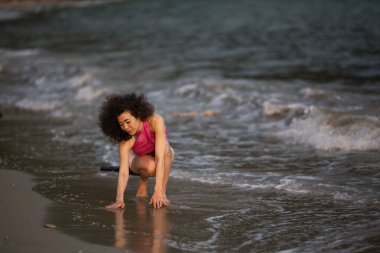 Deniz kıyısındaki sörf hattındaki dalgalarda melez bir kadın..