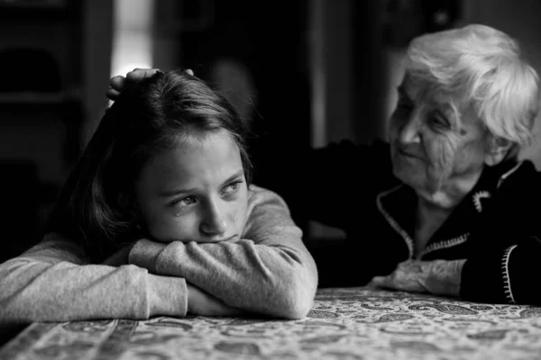 老太太安慰着一个哭哭啼啼的小女孩孙女 黑白照片 — 图库照片