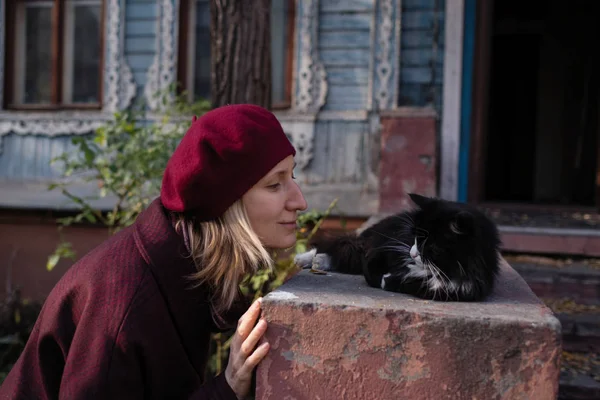Frau Mit Baskenmütze Spielt Mit Einer Katze Auf Der Veranda — Stockfoto