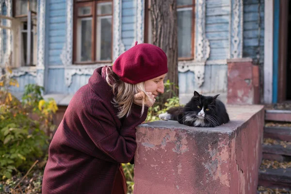 Frau Weinrotem Mantel Und Baskenmütze Mit Katze Auf Der Veranda — Stockfoto