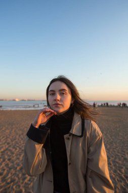 Yağmurluk giymiş genç bir kadın, açık havada portre..