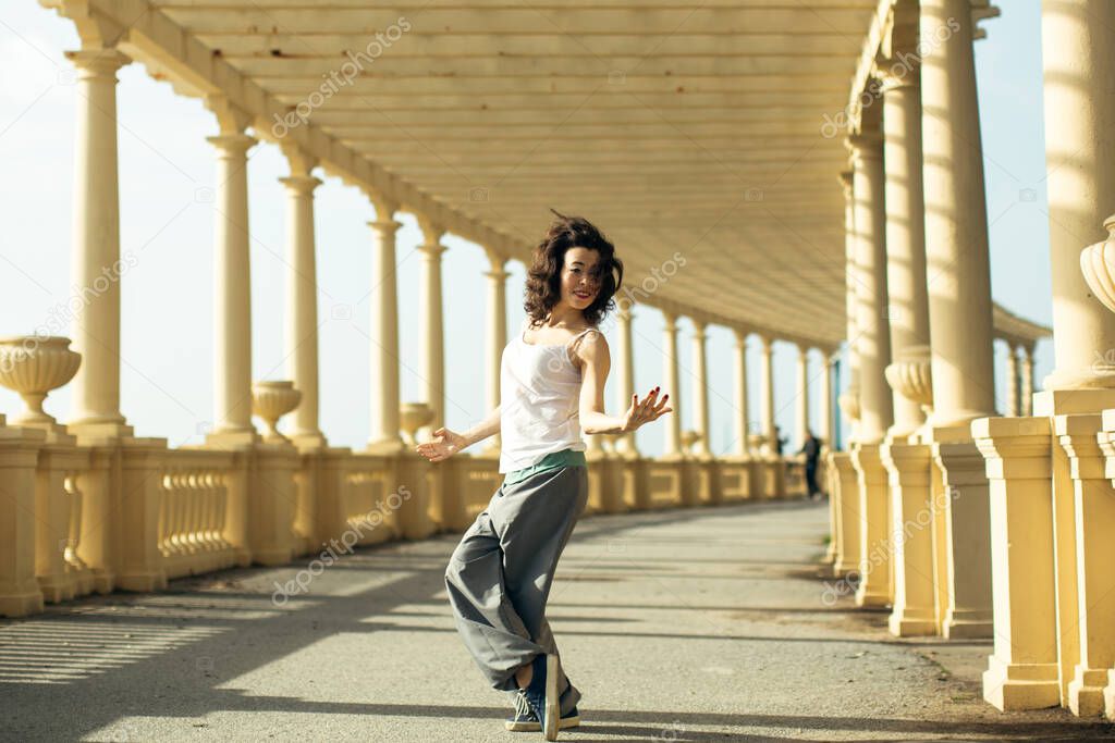 Multicultural woman does outdoor choreography on atlantic promenade in Porto, Portugal.