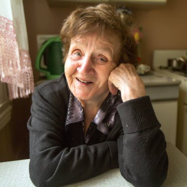 Olumlu bir yaşlı kadın evinde. Portre.