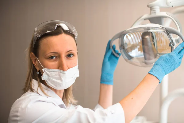 Portret Van Een Vrouwelijke Tandarts Met Een Lamp Een Tandheelkundige — Stockfoto