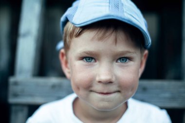 Küçük ironik çocuk, yakın plan portre. Köyün çocukları dışarıda..