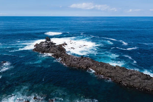 Flying over the ocean surf on the reefs coast of San Miguel island, Azores, Portugal.