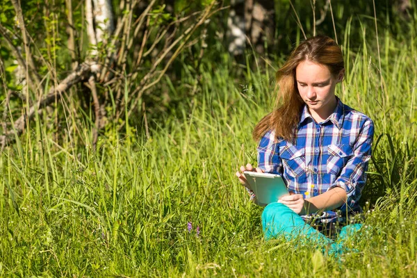 Parktaki Çimlerin Üzerinde Tabletli Genç Kız — Stok fotoğraf