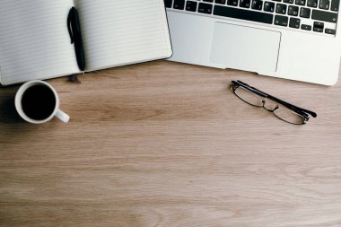 Kalem, dizüstü bilgisayar, bardak ve bir fincan kahve ile en iyi Not Defteri görünümü.