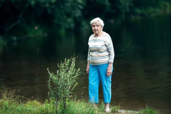 Пожилая Женщина Стоит Берегу Лесного Озера — стоковое фото