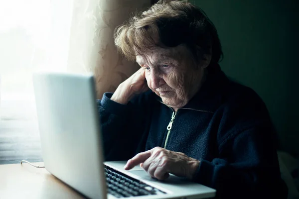 家でノートパソコンを使ってるロシア人の老婦人 — ストック写真