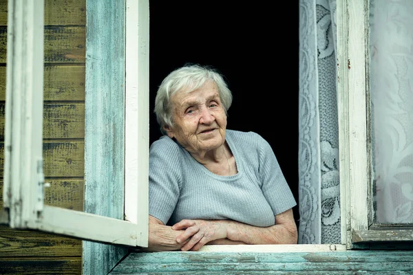 Una Vecchia Donna Guarda Fuori Dalla Finestra Una Casa Paese — Foto Stock