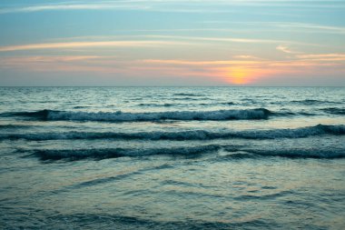 Güzel günbatımından sonra serin tonlarda deniz pelerini.