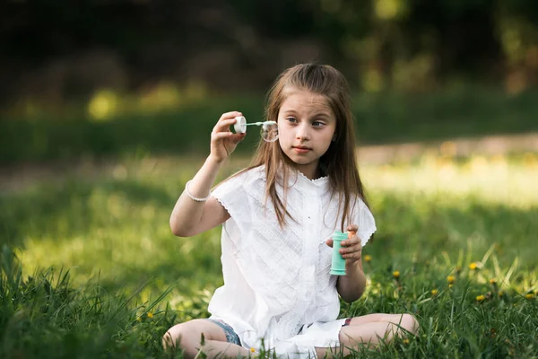 Tien Jarig Meisje Blaast Bubbels Zittend Het Gras Het Park — Stockfoto