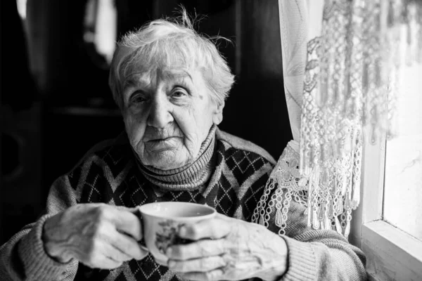 Una Vecchia Donna Che Beve Guardando Fuori Dalla Finestra Fotografia — Foto Stock