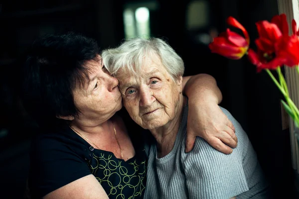 Een Oude Vrouw Omhelst Met Haar Volwassen Dochter Stockfoto