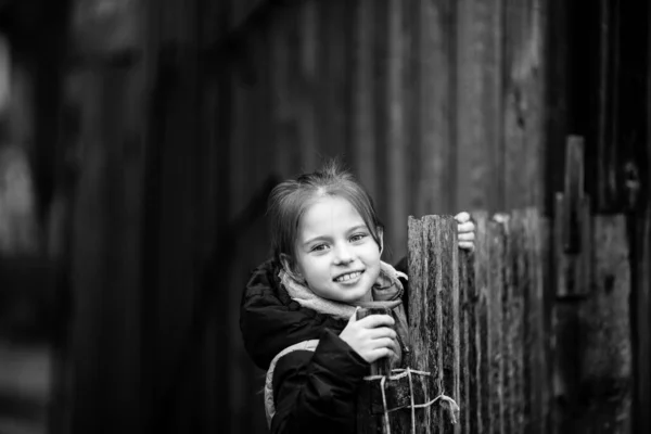 村中一个小女孩在木栅栏后面的画像 黑白摄影 — 图库照片