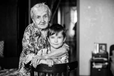 Kameraya poz veren yaşlı kadın ve torun. Siyah beyaz fotoğraf. 