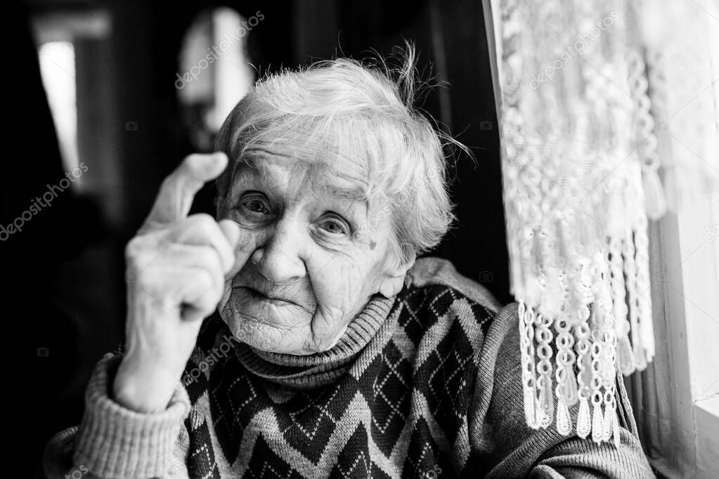 Portrait of an elderly woman indignantly wags her finger. Black and white photography.