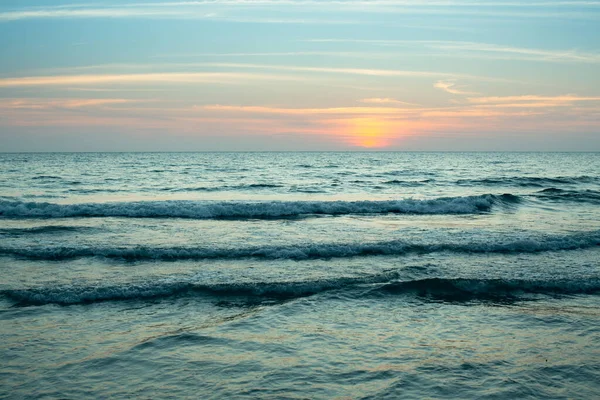 An evening surf of the sea during sunset.