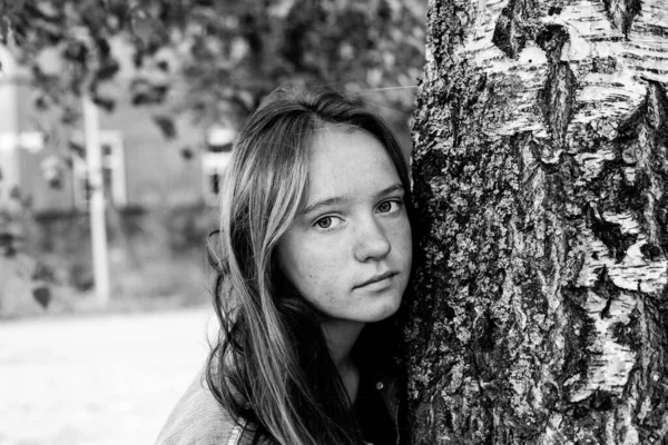 木の近くに長い髪の肖像画を持つ10代の女の子 白黒写真 — ストック写真