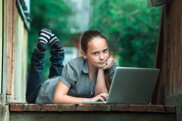 Teengirl带着笔记本电脑躺在农舍的门廊上 — 图库照片