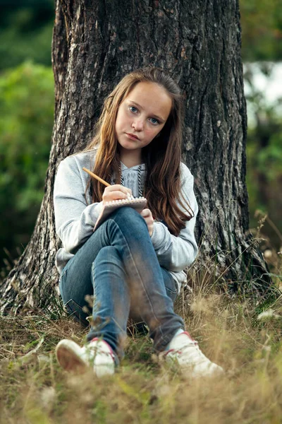 Dospívající Dívka Psaní Notebooku Zatímco Sedí Parku Royalty Free Stock Obrázky