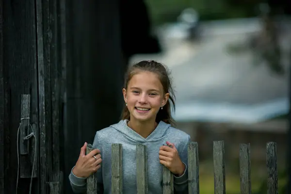 10代の女の子は農場の木製のヘッジに立っています — ストック写真
