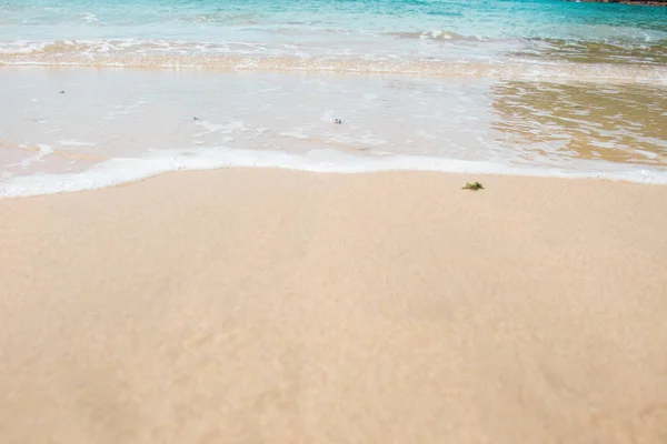 Água azul e espuma do mar na areia — Fotografia de Stock