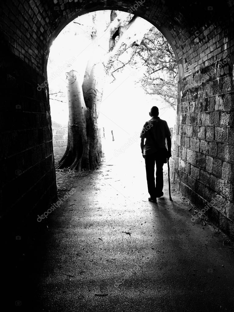 Into the Light.  Black and white shot of silhouetted figure walking into the light.