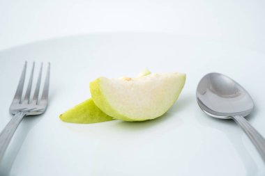 Sağlık meyve yeme, çatal ve kaşık beyaz tabakta guava