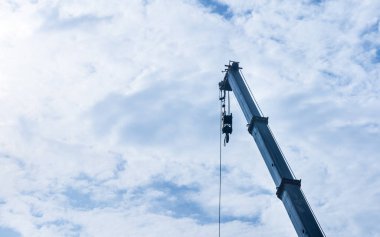 hoist crane hook head with blue sky cloud background