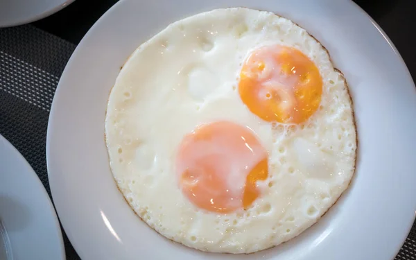 Two fried egg on the white plate on breakfast table — Stock Photo, Image