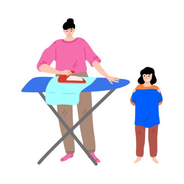 Mutlu kız ayakta, elinde tişörtle ve ütü yaparken annesine yardım ediyor.