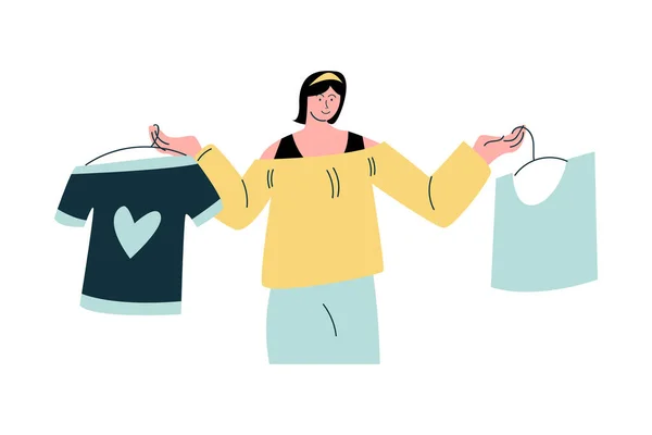 Молодая женщина выбирает между двумя футболками во время шопинга — стоковый вектор