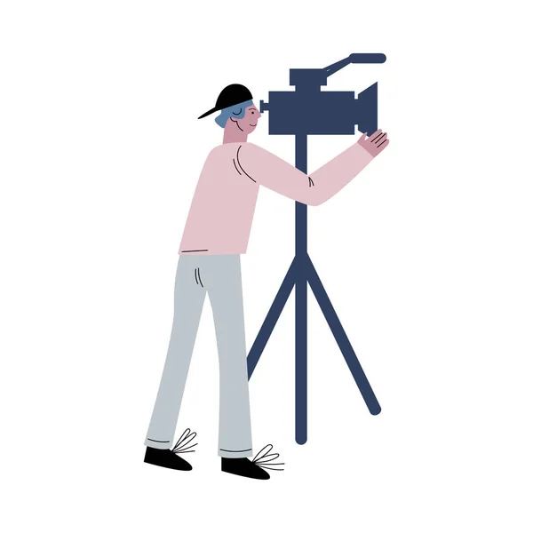 Młody kamerzysta pracujący z kamerą podczas produkcji kinowej — Wektor stockowy