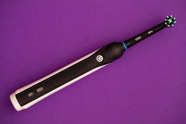  Elektrikli diş fırçasının kapanışı Oral-B Cross Action PRO 750 siyah baskı mor zemin üzerine