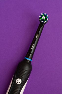  Elektrikli diş fırçasının kapanışı Oral-B Cross Action PRO 750 siyah baskı mor zemin üzerine