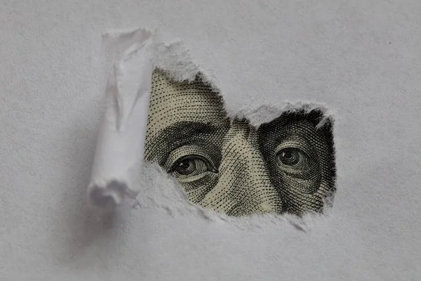 引き裂かれた白い紙を通してベンジャミン フランクリンのマクロ ピーク — ストック写真