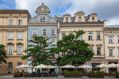 Krakow, Polonya - 19 Ağustos 2025: Krakow 'daki Ana Pazar Meydanı' nda açık kafeli tarihi binalar.