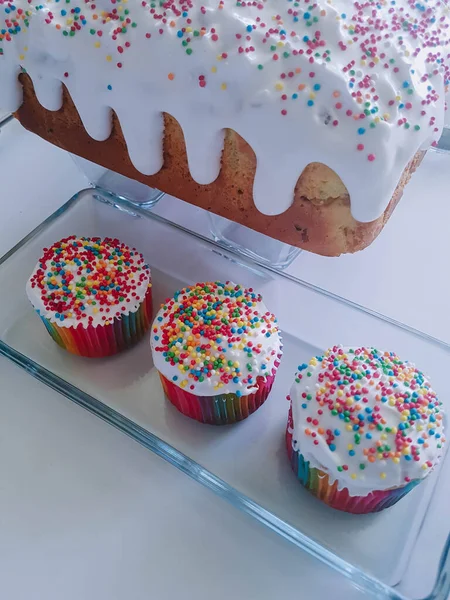 Easter mini cupcakes in glass plate. White icing with colorful sprinkles. Homemade bakery, dessert, holiday and cooking bakery.